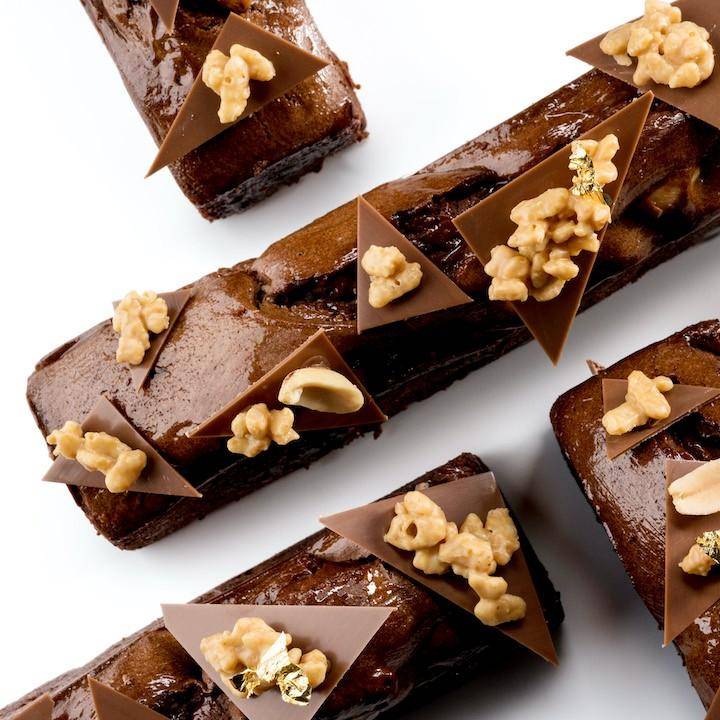 A stack of granola-bar style brownies with visible oats and seeds