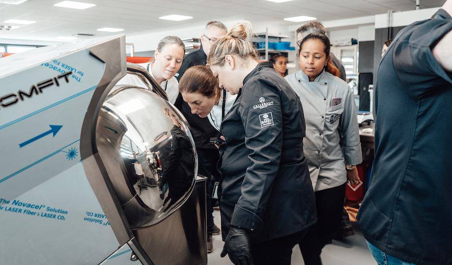 Sarah Frankland, Clare England, and chefs working with a Panning Machine at Selmi Headquarters